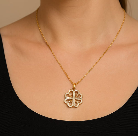 Gold plated anti-tarnish magnetic heart clover pendant necklace on a model wearing a black top.